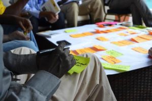 Participants at the Open Standards workshop in Kenya discuss the details of a results chain and brainstorm strategies. Photo by Felix Cybulla. 